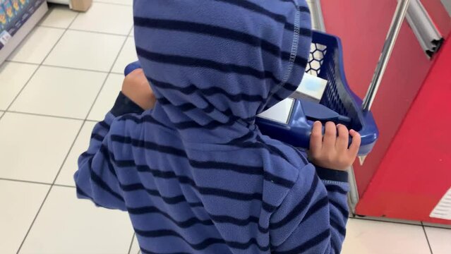 Ni&ntilde;o peque&ntilde;o empuja un carro de compra por un comercio