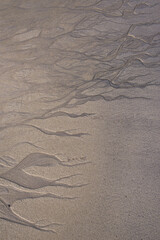 Natural texture of sand. Abstract beautiful drawings on the sand. Paintings in the sand
