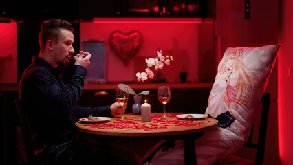 Man and anime waifu dakimakura having a romantic Valentine's dinner at home