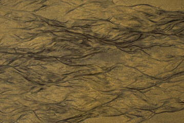 Natural texture of sand. Abstract beautiful drawings on the sand. Paintings in the sand
