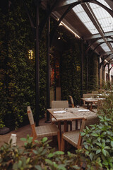 cafe terrace under transparent roof near building covered with green ivy in New York City.