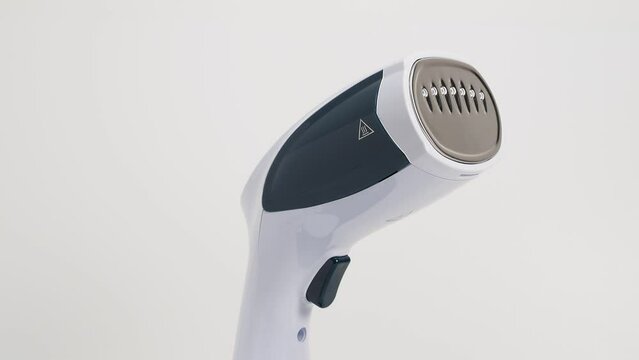 Steamer for clothes on a white background. Portable iron. Iron for ironing clothes.