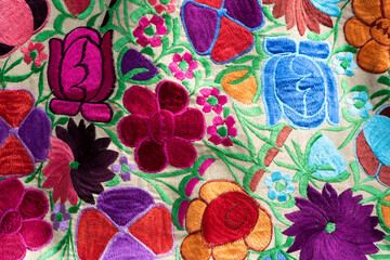 Fototapeta na wymiar Hand-embroidered fabric with colorful flowers from Chiapas, Mexico