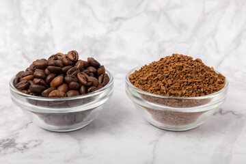 Coffee granules and coffee beans on a white marble background. Instant coffee drink. Energy hot drink. Place for text. Place for copy. Cheerful morning concept.
