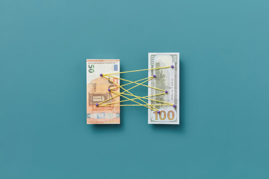 Dollar and euro attached with pins and threads.