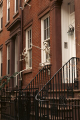 house with Halloween skeletons on white windows in Brooklyn Height district of New York City.