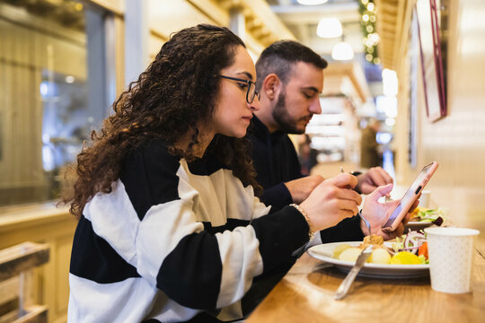 Woman Sitting In A Lunch Place Looking At Phone