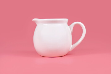 White creamer pitcher on pink background