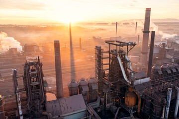 Smelter with blast furnaces from above during autumn foggy morning. Heavy industry plant during sunrise.