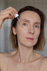 Fototapeta premium Serum skin care female wellness routine. Portrait of woman.