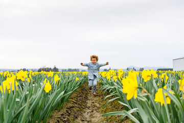 child playing in a daffodil field