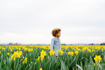 child playing in a daffodil field