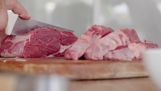 Cook at Traditional Churrasco Brazilian Barbecue. Preparing and cutting Ancho meat