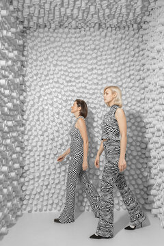 Conceptual portrait of two attractive girls walking in step