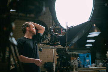 Director of photography with a camera in his hands on the set. Professional videographer at work on filming a movie