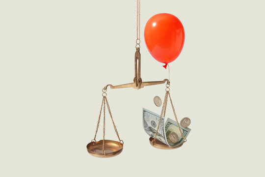 Dollar on vintage scales with red balloon.