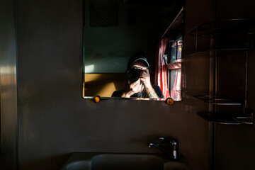 Self-portrait of a photographer in a mirror on an old Thai train