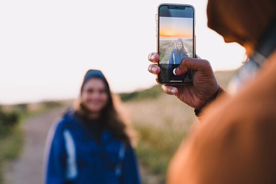 Man Taking Cellphone Picture of Woman