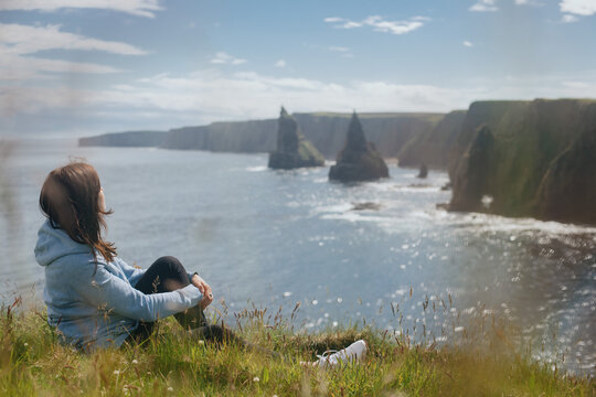 Woman relaxing at Sea Stacks At Duncansby Head. Highlands, Scotland