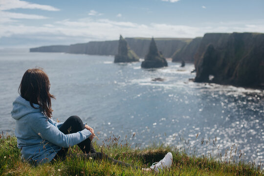 Woman relaxing at Sea Stacks At Duncansby Head. Highlands, Scotland