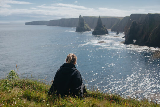 Woman relaxing at Sea Stacks At Duncansby Head. Highlands, Scotland
