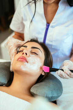 Female cosmetologist doing procedure for client