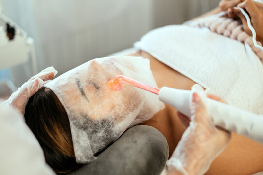 Beautician performing darsonvalization in salon