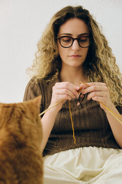Woman knitting with a cat