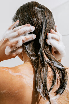 A woman washes her hair in the shower