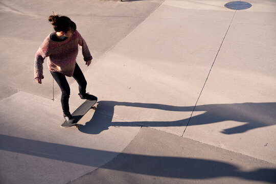 Beautiful young woman skateboarding in a skate park 