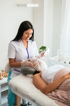 Beautician performing darsonvalization in salon