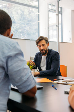 Coworkers talking at office table