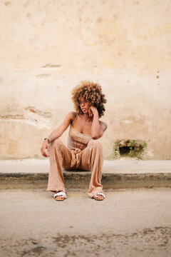 Stylish Cuban woman sitting on border