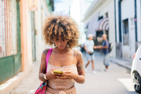 Cuban female texting on cellphone