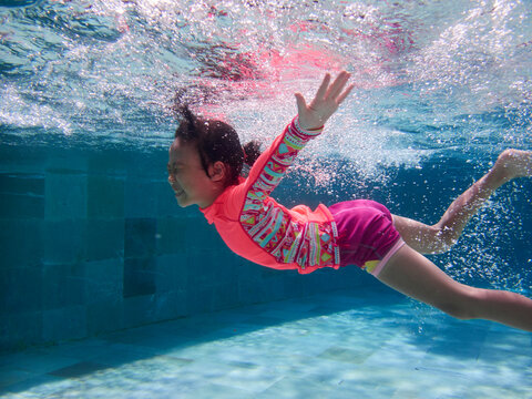 Asian Little Girl Swimming Happily In The Pool