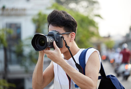 Close up Asian male photographer, shooting on the street