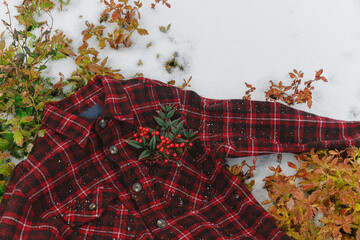 A red plaid shirt and a branch with red fruits.