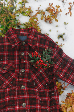 A red checkered shirt on a snowy garden.