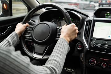 Woman driving a car with both hands on steering wheel