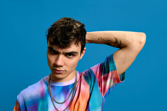 Rebellious young guy in blue studio