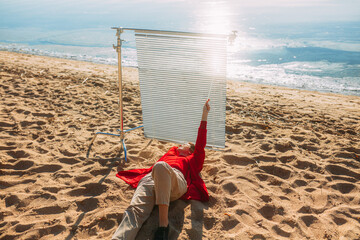Obraz premium A person with his blinds is relaxing on the beach adjusting comfort