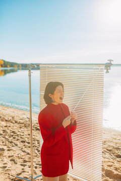 The girl yawns from boredom and hides from the sunlight