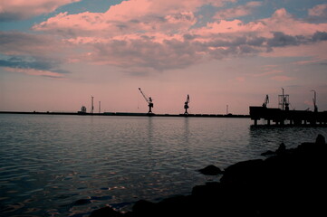 A port silhouette with pink sky