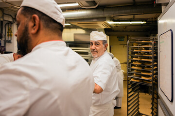 Mature chef working with colleagues