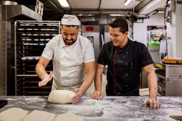 Baker teaching colleague to make dough