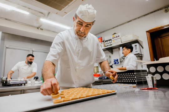 Mature man arranging tartlet shells