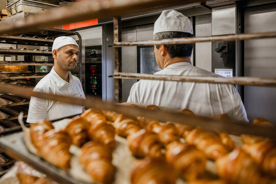 Male bakers speaking in kitchen