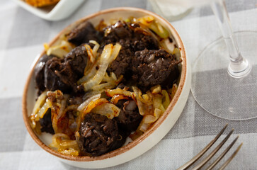 Grilled traditional Spanish morcilla blood sausage slices with rice served with onions..