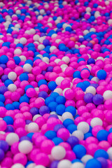 Background, close-up texture of many colored, multi-colored round plastic small balls on the playground for children's games. Photo, top view, copy space.
