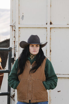 woman rancher standing behind horse trailer